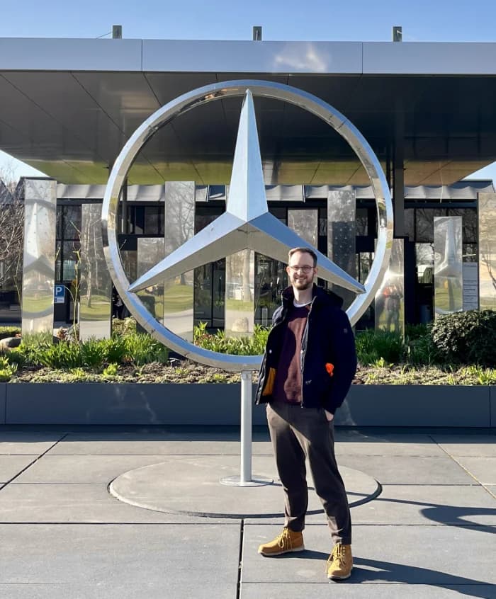 Sebastian standing in front of the Mercedes-Benz star in Stuttgart